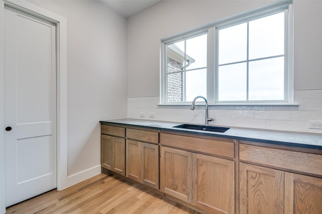 9813 Aiken Ct, Mesquite, TX 75126 - kitchen with a sink, backsplash, light wood-style flooring, and baseboards