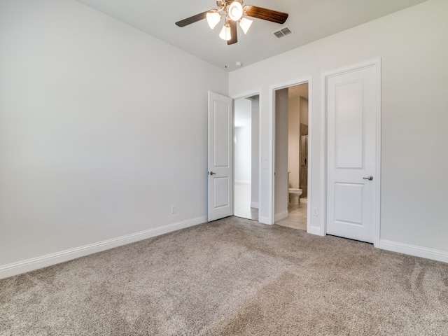 unfurnished bedroom with ensuite bathroom, carpet floors, and ceiling fan