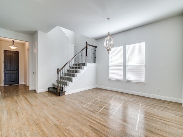 spare room featuring light hardwood / wood-style floors and a chandelier