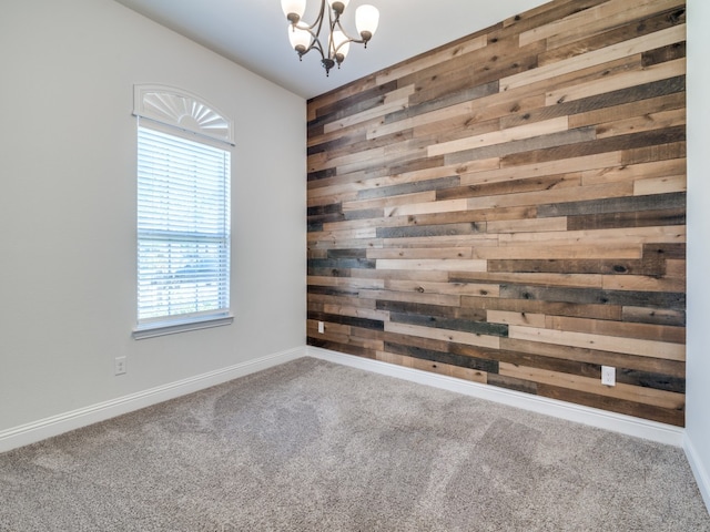 unfurnished room with carpet flooring, wood walls, and a chandelier