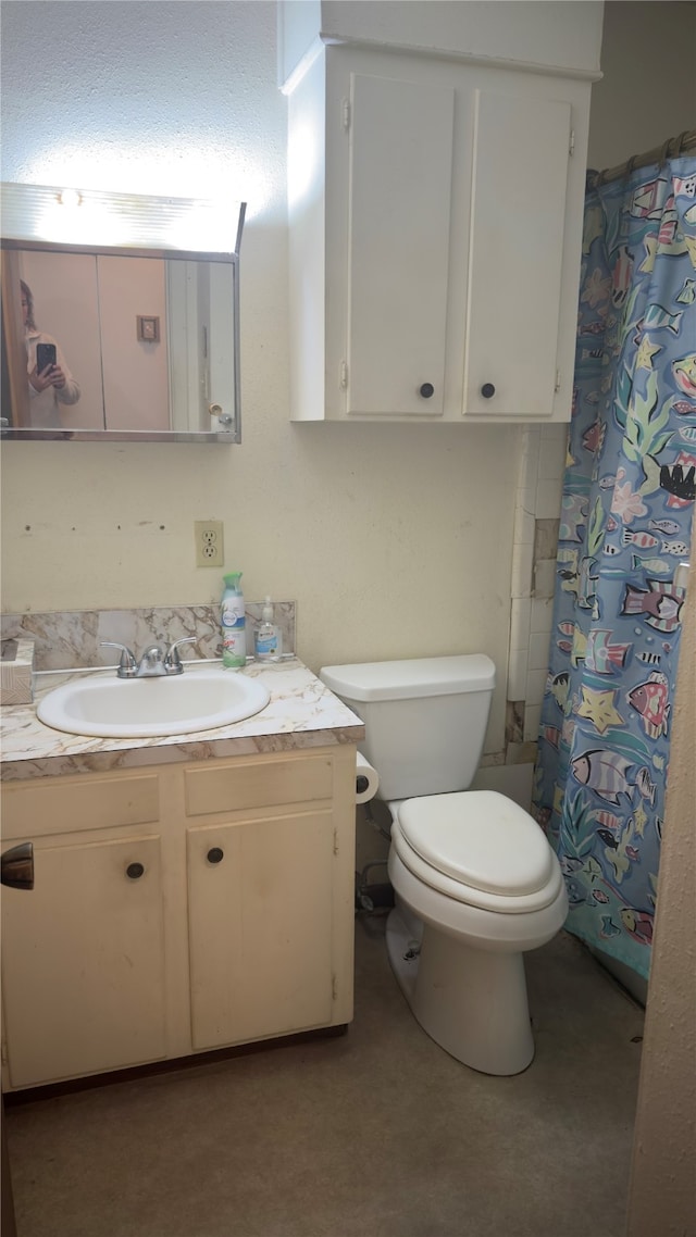 bathroom with toilet, vanity, and walk in shower