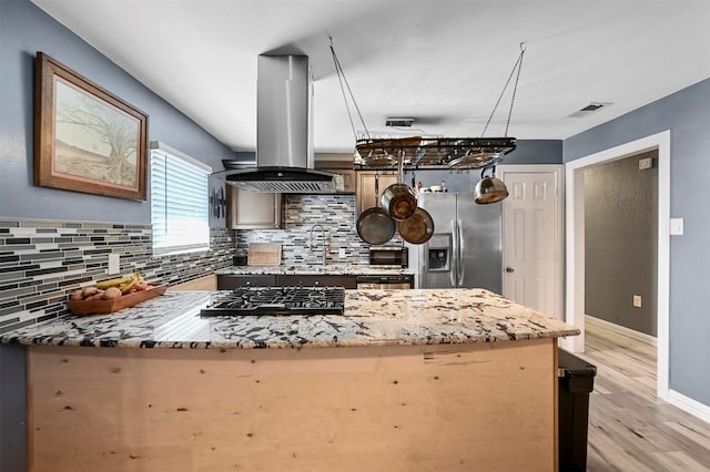 1246 Woodburn Trl, Dallas, TX 75241 - kitchen with island exhaust hood, stainless steel refrigerator with ice dispenser, a peninsula, decorative backsplash, and light wood finished floors