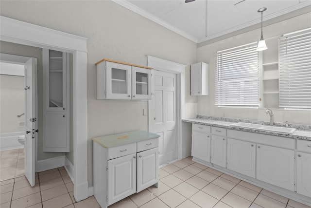 kitchen with white cabinetry, sink, decorative light fixtures, and crown molding