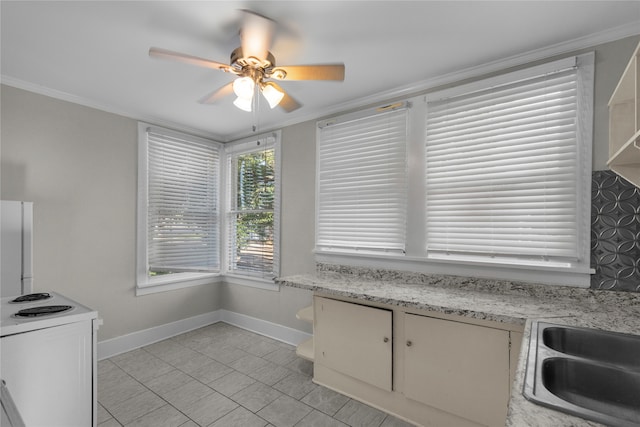 kitchen featuring light stone countertops, light tile patterned floors, ceiling fan, and crown molding