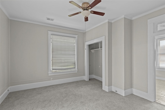 unfurnished bedroom with a closet, light colored carpet, ceiling fan, and crown molding