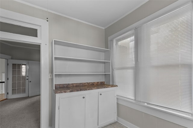 bar featuring white cabinets, light colored carpet, and crown molding