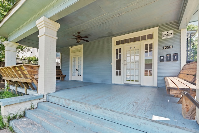 entrance to property featuring ceiling fan, french doors, and a porch