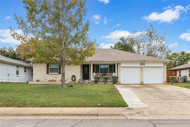 ranch-style home with a garage, cooling unit, and a front yard