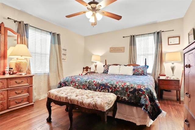 bedroom with light wood-type flooring, multiple windows, and ceiling fan