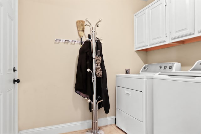 clothes washing area featuring separate washer and dryer, cabinets, and light tile patterned floors