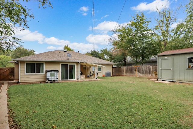 rear view of house with central air condition unit, a patio area, a lawn, and a storage shed