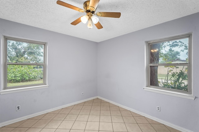 empty room with a textured ceiling, light tile patterned floors, and ceiling fan