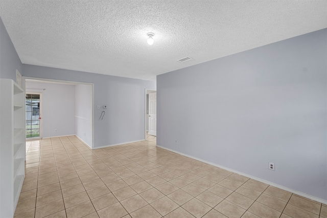 tiled spare room featuring a textured ceiling