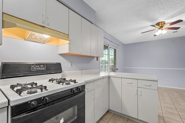 kitchen featuring white cabinetry, a textured ceiling, white gas range, light tile patterned floors, and kitchen peninsula