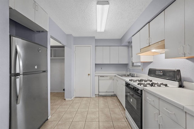 kitchen with a textured ceiling, sink, light tile patterned floors, white cabinetry, and white appliances