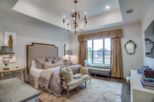 bedroom featuring wood-type flooring, a notable chandelier, ornamental molding, and a raised ceiling