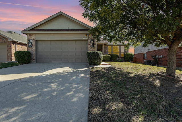 ranch-style home with a garage and a yard