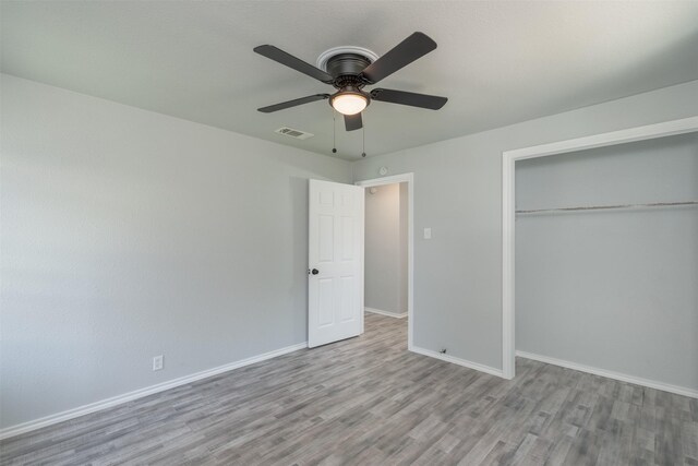 unfurnished bedroom with ceiling fan, a closet, and light hardwood / wood-style flooring