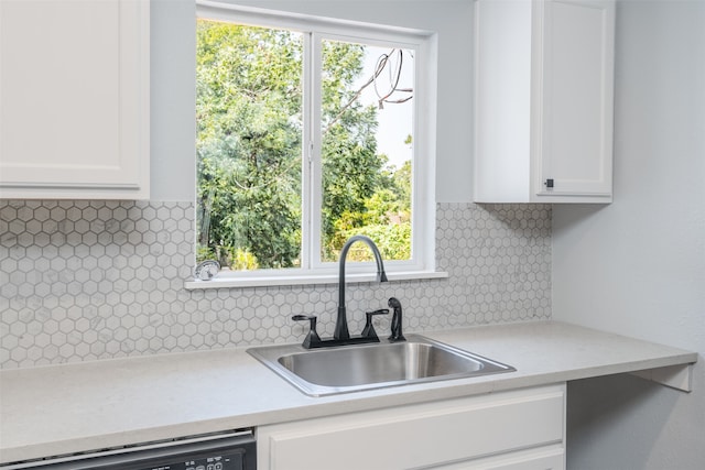 kitchen featuring backsplash, sink, and white cabinets