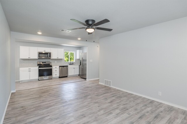 spare room with light wood-type flooring and ceiling fan