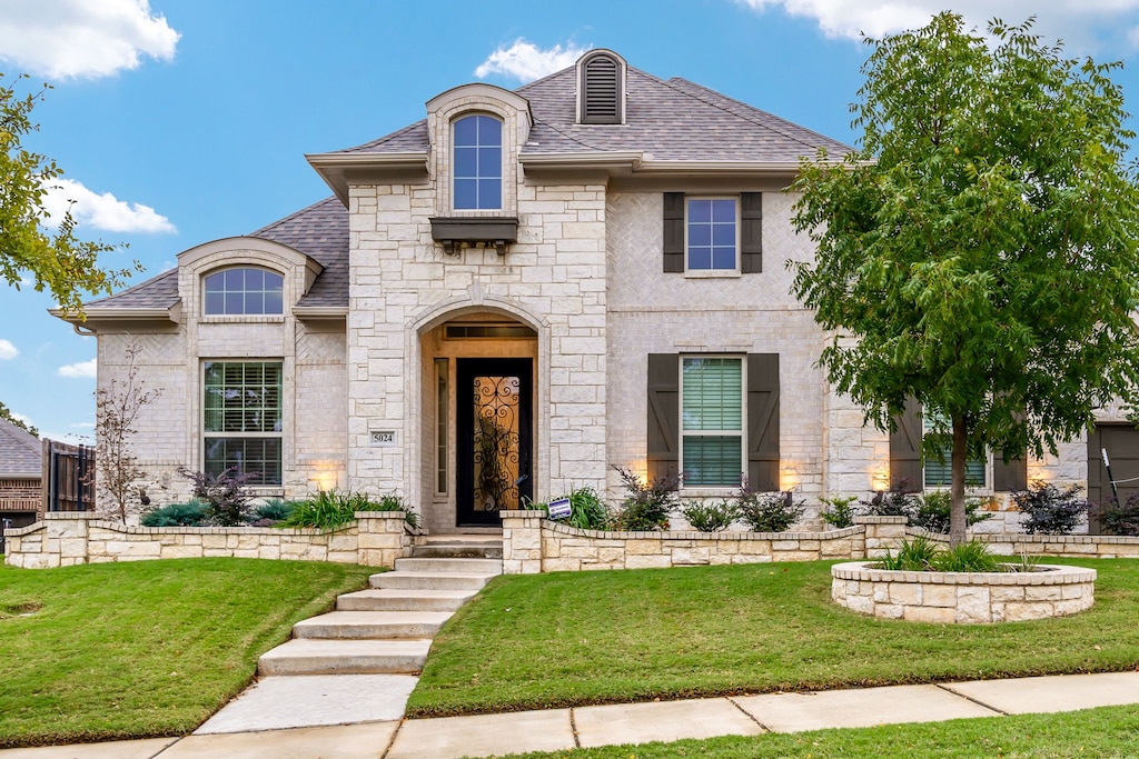 french provincial home featuring a front yard