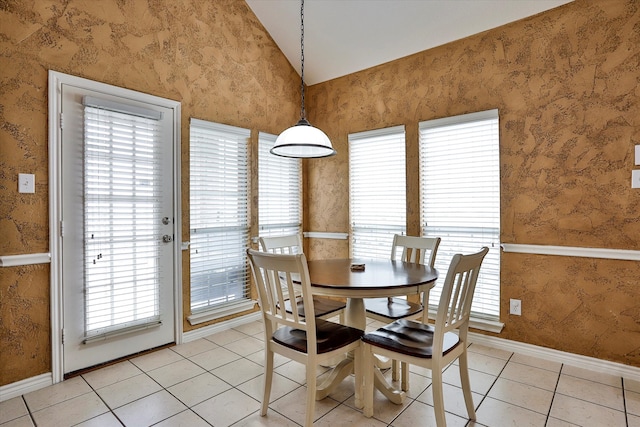 tiled dining space featuring lofted ceiling