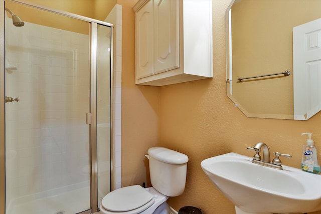 bathroom featuring toilet, sink, and walk in shower