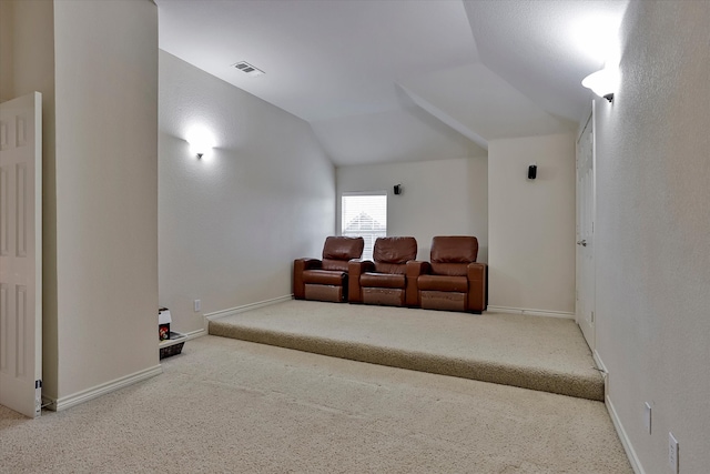 carpeted cinema room with vaulted ceiling