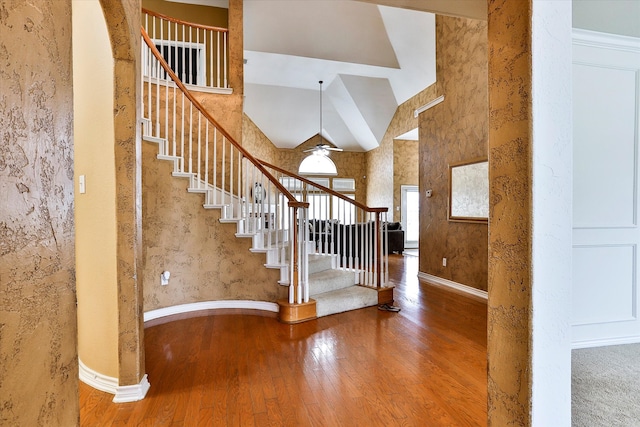 foyer entrance featuring wood-type flooring and high vaulted ceiling