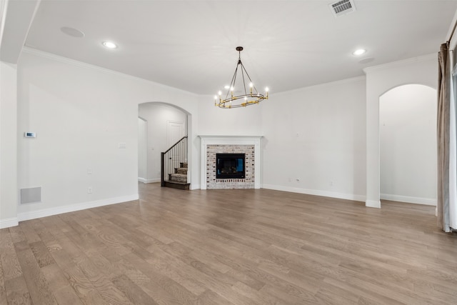 unfurnished living room featuring light hardwood / wood-style floors, an inviting chandelier, and ornamental molding