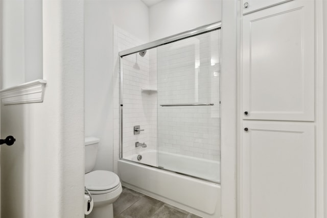 bathroom with enclosed tub / shower combo and toilet