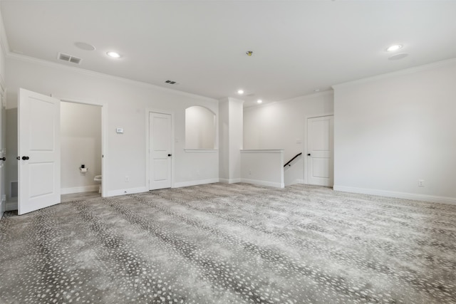 spare room with ornamental molding and carpet