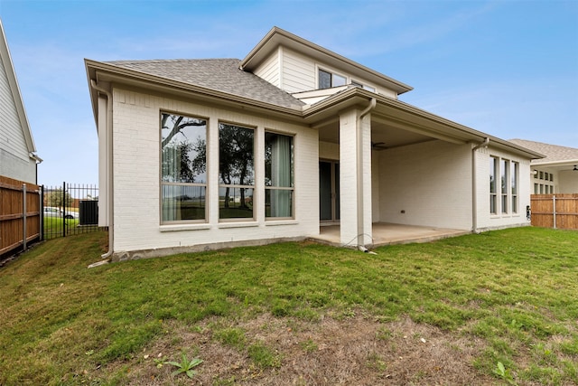 rear view of house featuring a lawn, ceiling fan, and a patio area