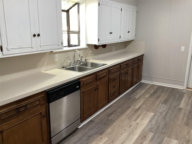 604 S Seaman St, Eastland, TX 76448 - kitchen with dishwasher, a sink, wood finished floors, white cabinetry, and baseboards
