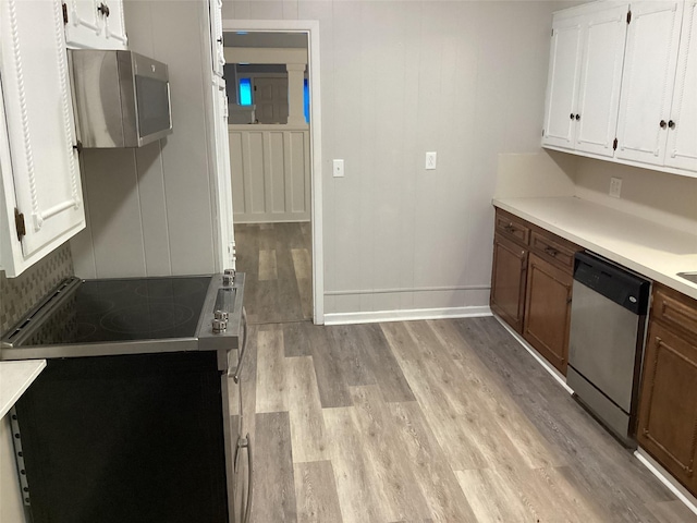 604 S Seaman St, Eastland, TX 76448 - kitchen featuring appliances with stainless steel finishes, light wood finished floors, white cabinets, light countertops, and baseboards