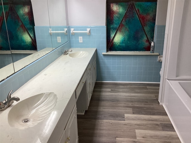 bathroom featuring hardwood / wood-style flooring, vanity, and tile walls