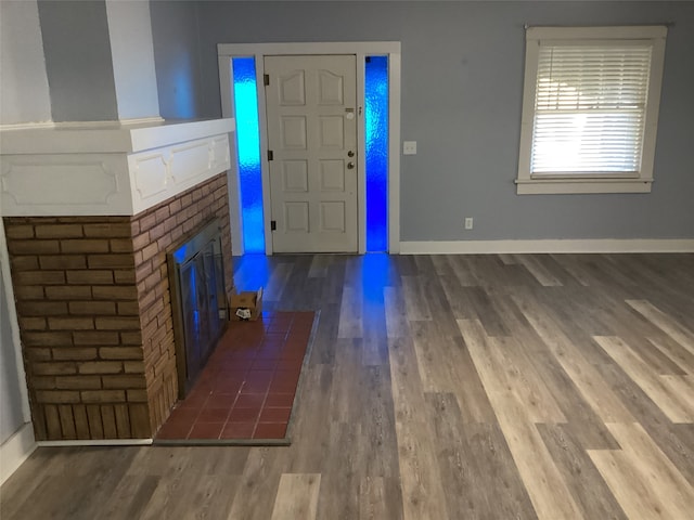 foyer entrance featuring hardwood / wood-style flooring and a fireplace