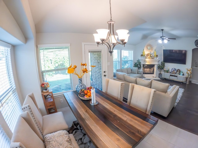 dining room featuring vaulted ceiling, ceiling fan with notable chandelier, and hardwood / wood-style floors