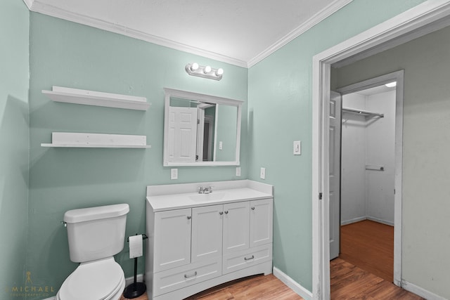 bathroom with toilet, hardwood / wood-style floors, vanity, and crown molding