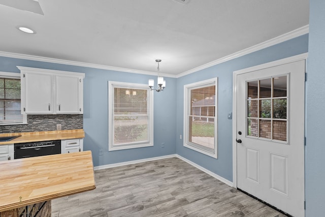 kitchen featuring white cabinetry, hanging light fixtures, and a healthy amount of sunlight