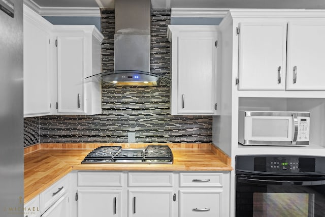 kitchen with white cabinetry, appliances with stainless steel finishes, and wall chimney exhaust hood