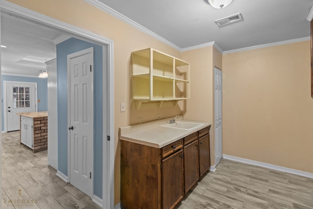 kitchen featuring light hardwood / wood-style floors, sink, and crown molding