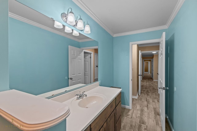 bathroom featuring hardwood / wood-style flooring, vanity, and crown molding