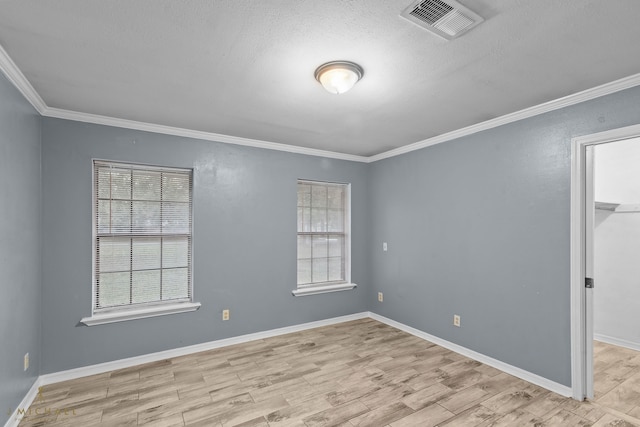 spare room with a textured ceiling, light hardwood / wood-style flooring, and ornamental molding