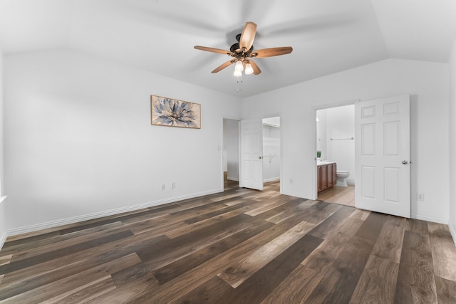 unfurnished bedroom with vaulted ceiling, ensuite bathroom, dark hardwood / wood-style flooring, and ceiling fan