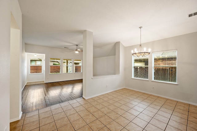 unfurnished dining area featuring ceiling fan with notable chandelier and light hardwood / wood-style flooring