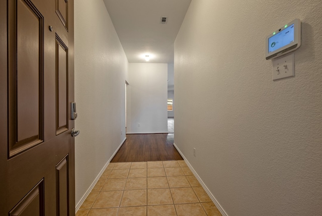 hall with light tile patterned floors