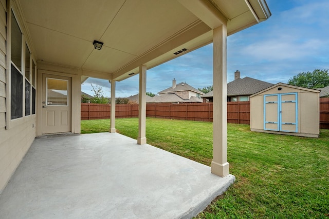 view of patio / terrace with an outbuilding, a storage unit, and a fenced backyard