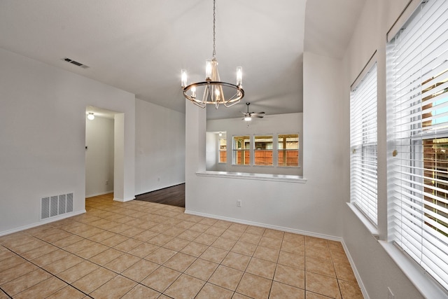 tiled empty room with ceiling fan with notable chandelier