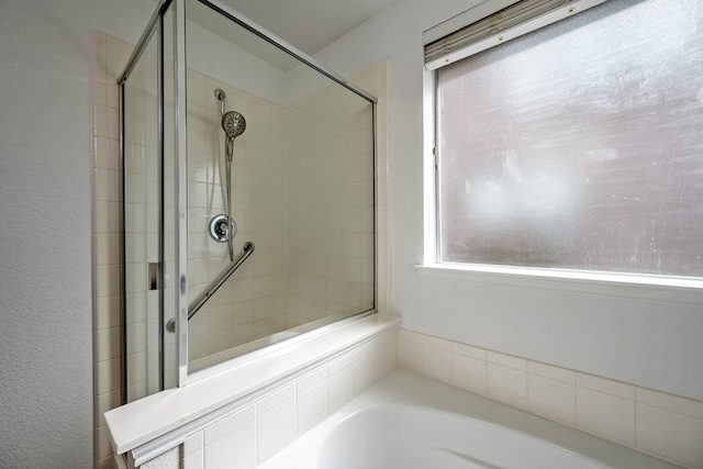 bathroom featuring shower with separate bathtub